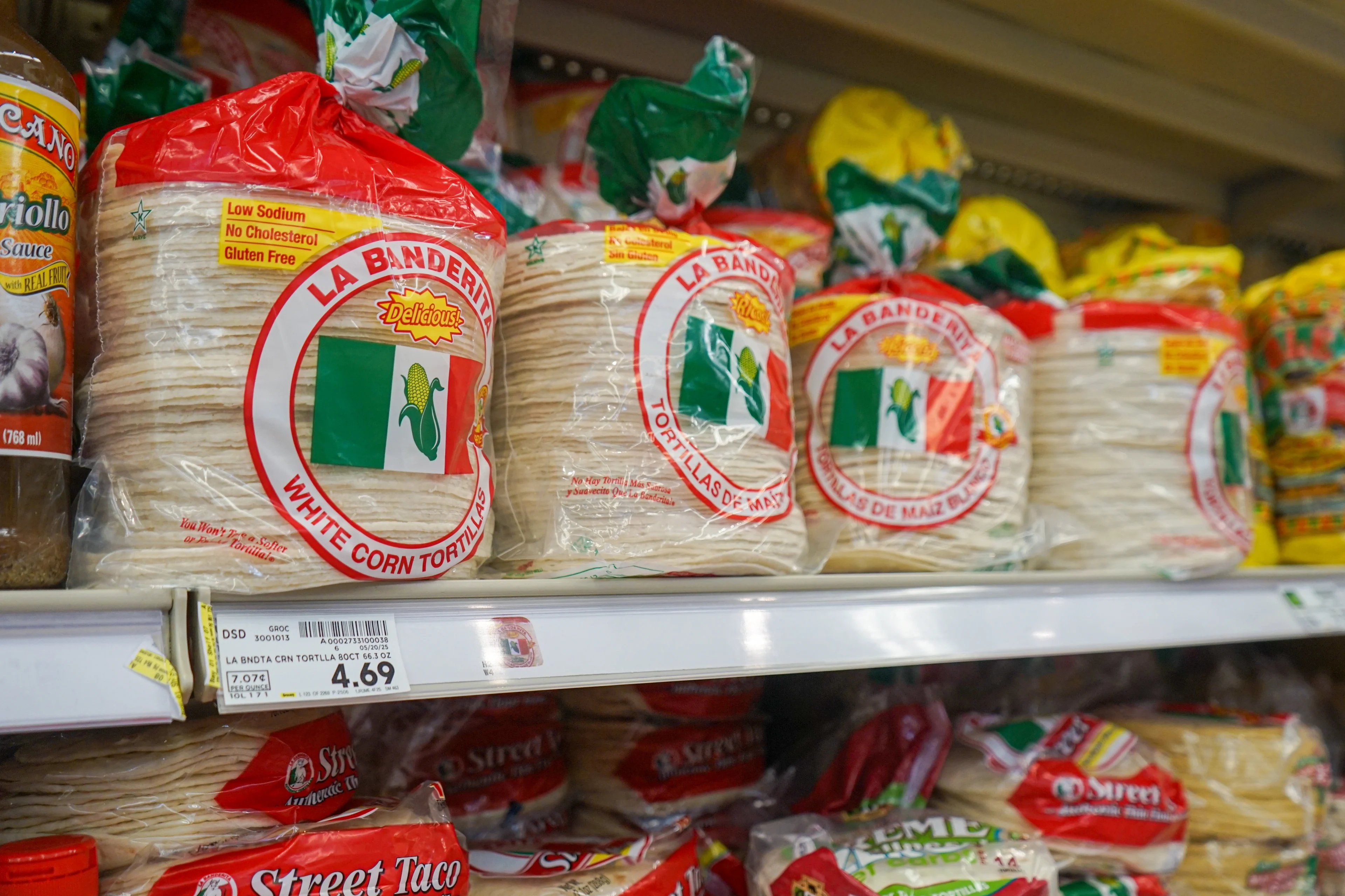 A stack of packaged tortillas sit on a grocery store shelf