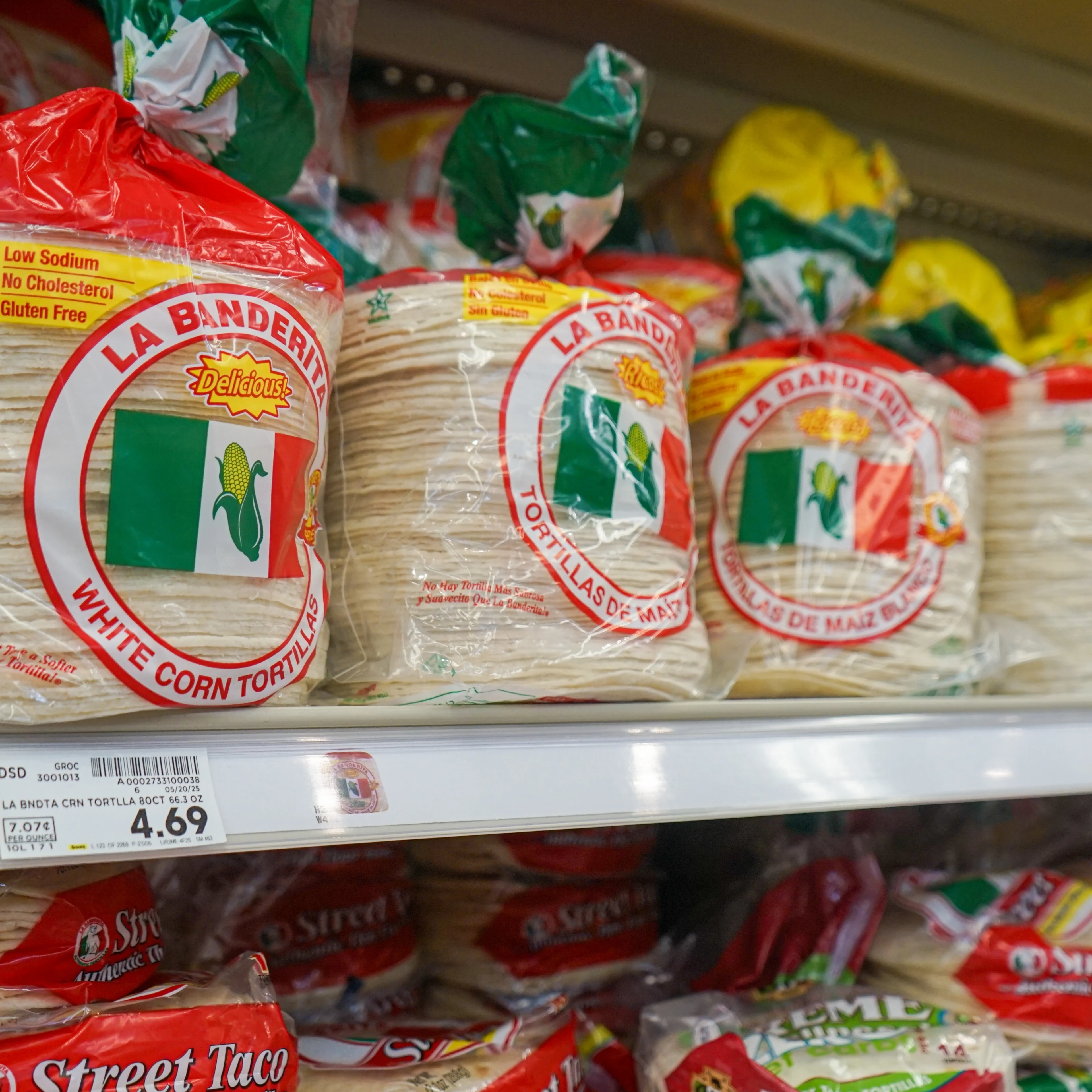 A stack of packaged tortillas sit on a grocery store shelf