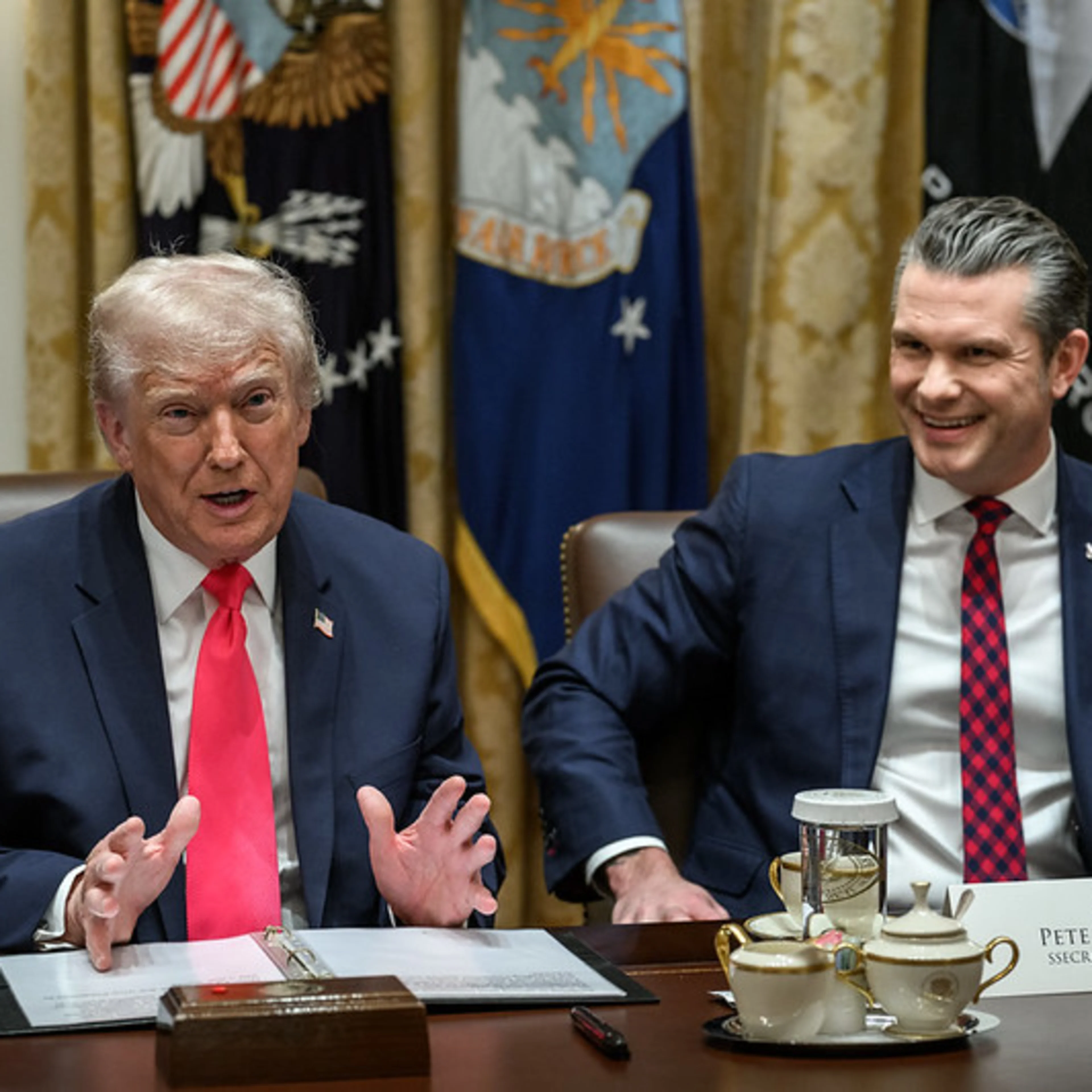 Two men in dark suits, seated