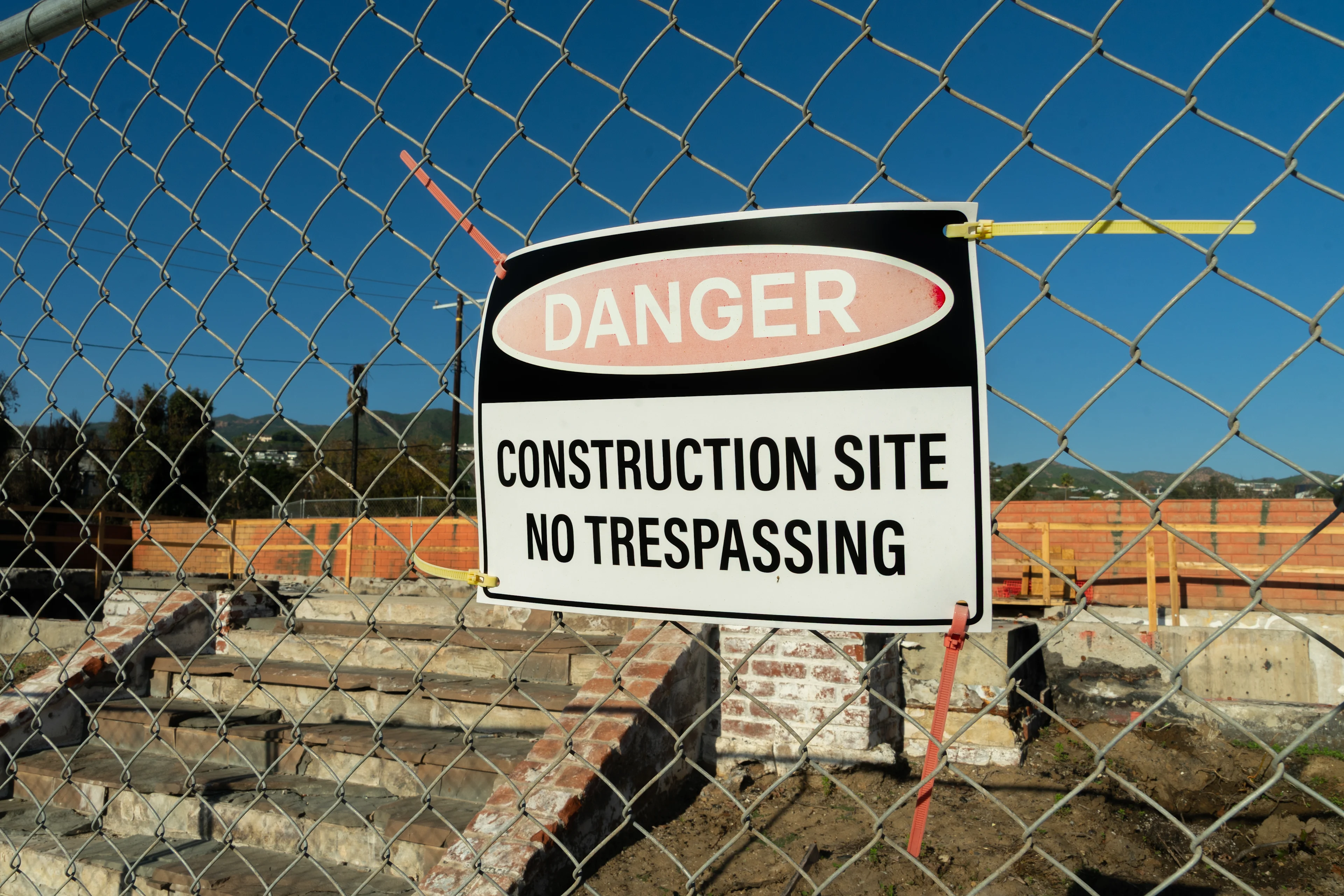 A sign that reads 'Danger: Construction Site, No Trespassing' in the Pacific Palisades one year after the Palisades Fire destroyed thousands of buildings.
