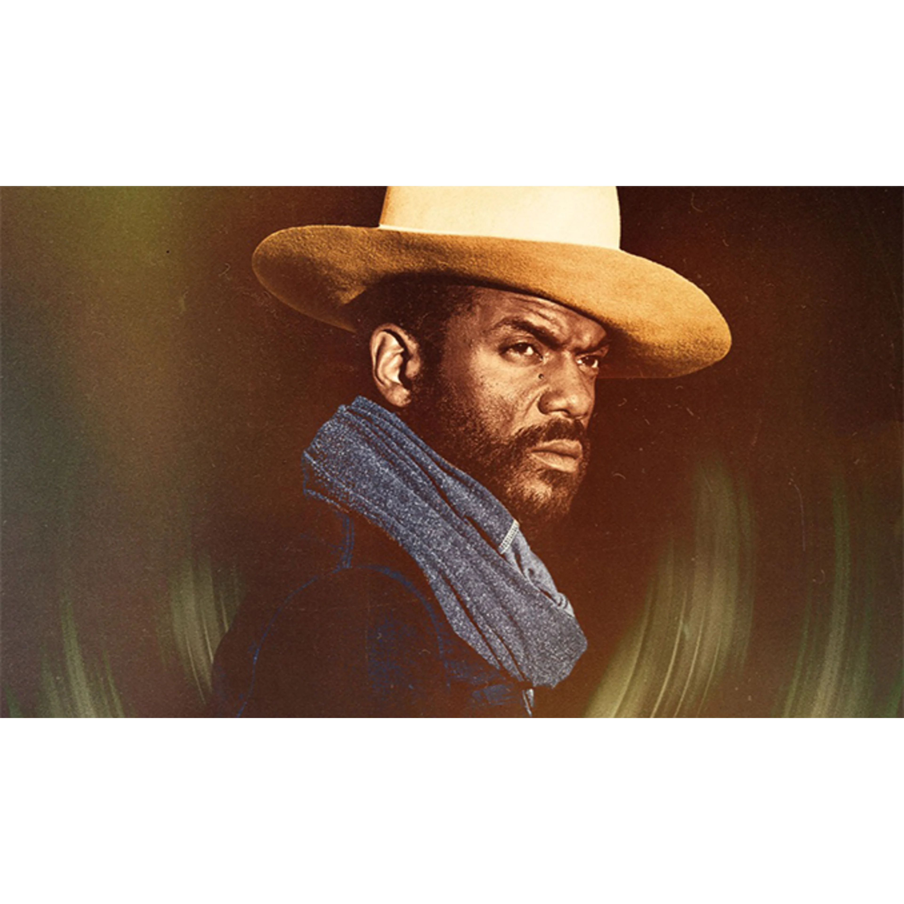 A man wearing a tan cowboy hat and blue scarf looks intensely to the side against a moody, dark green background.