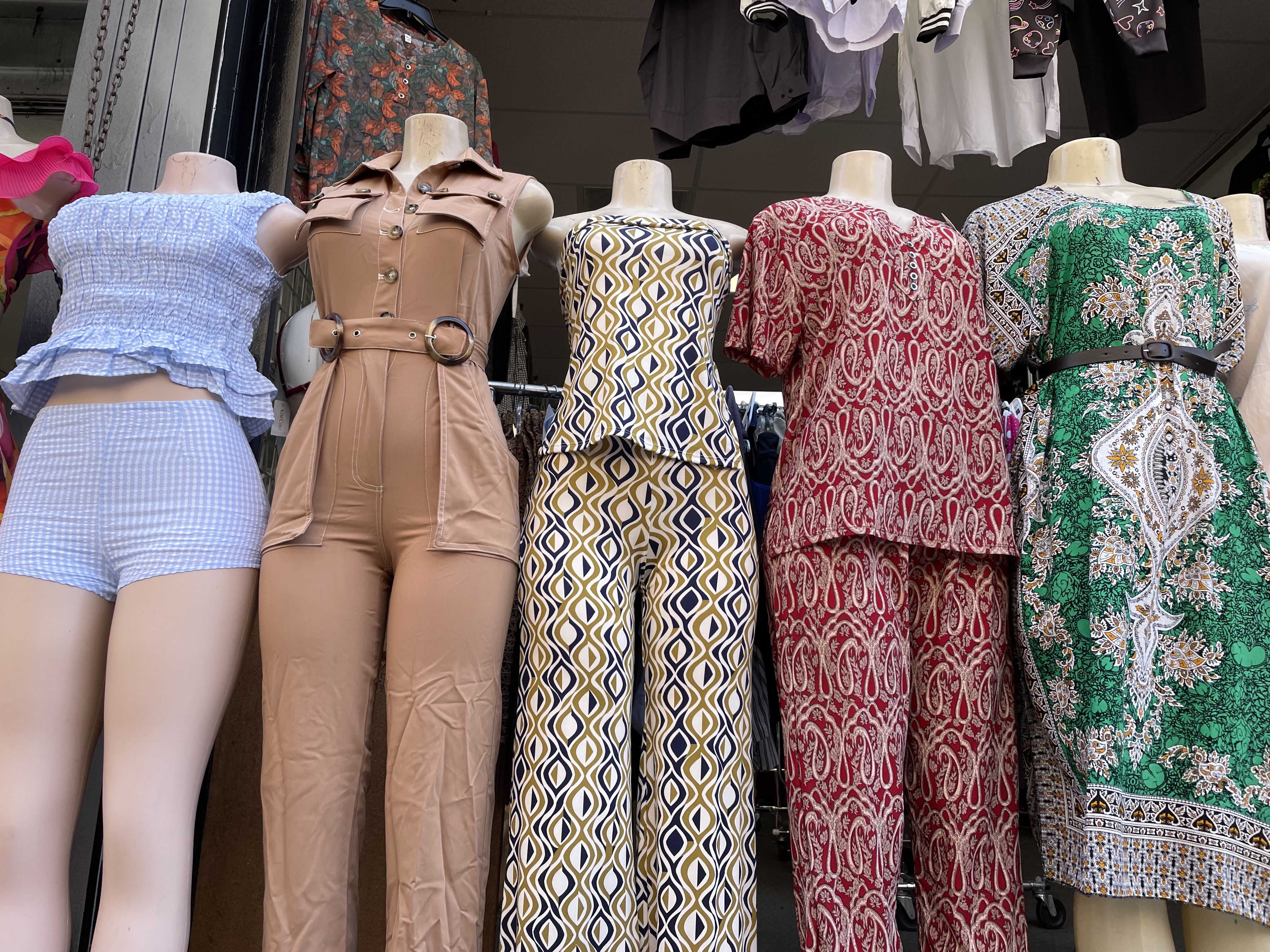 Mannequins dressed in clothing outside of a storefront