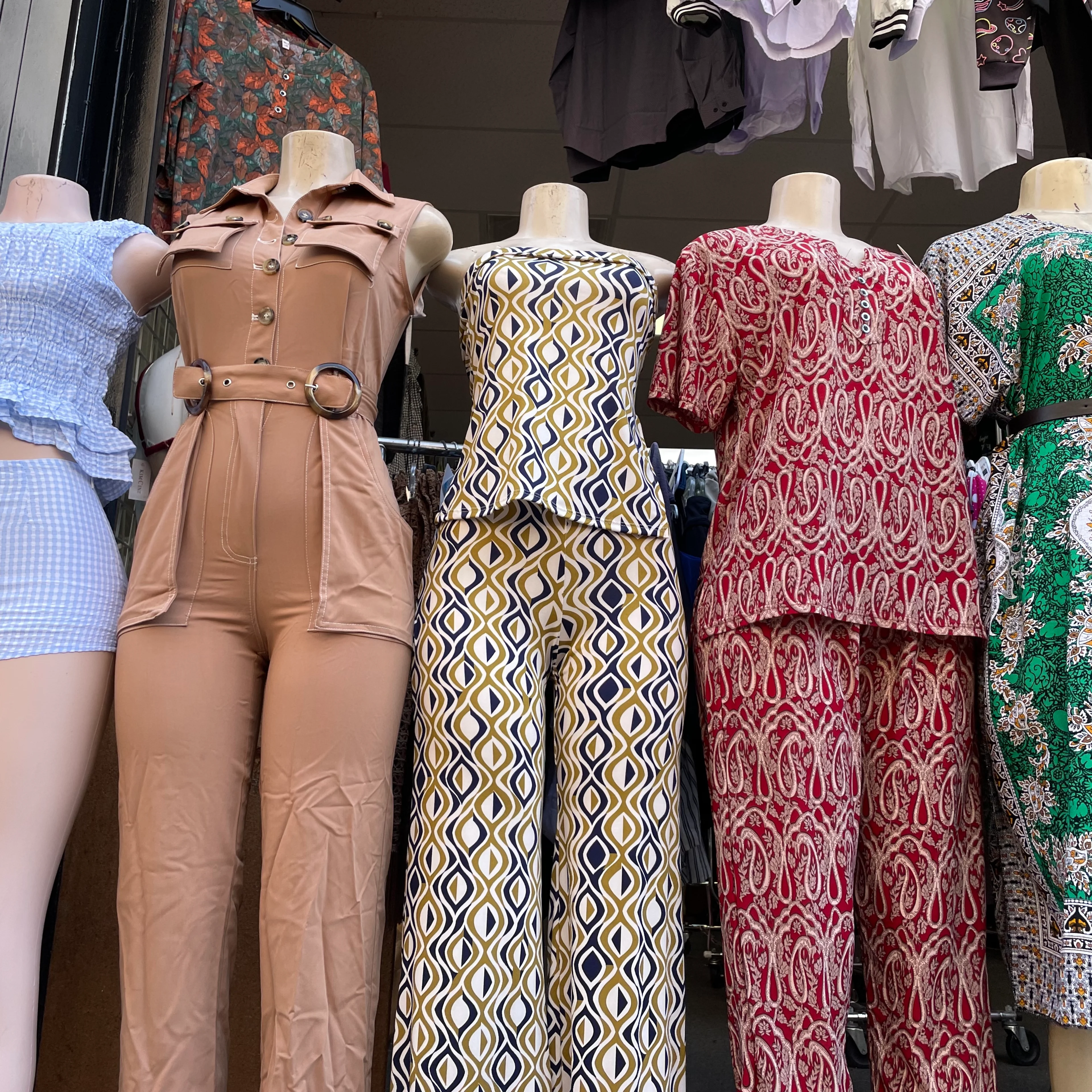 Mannequins dressed in clothing outside of a storefront