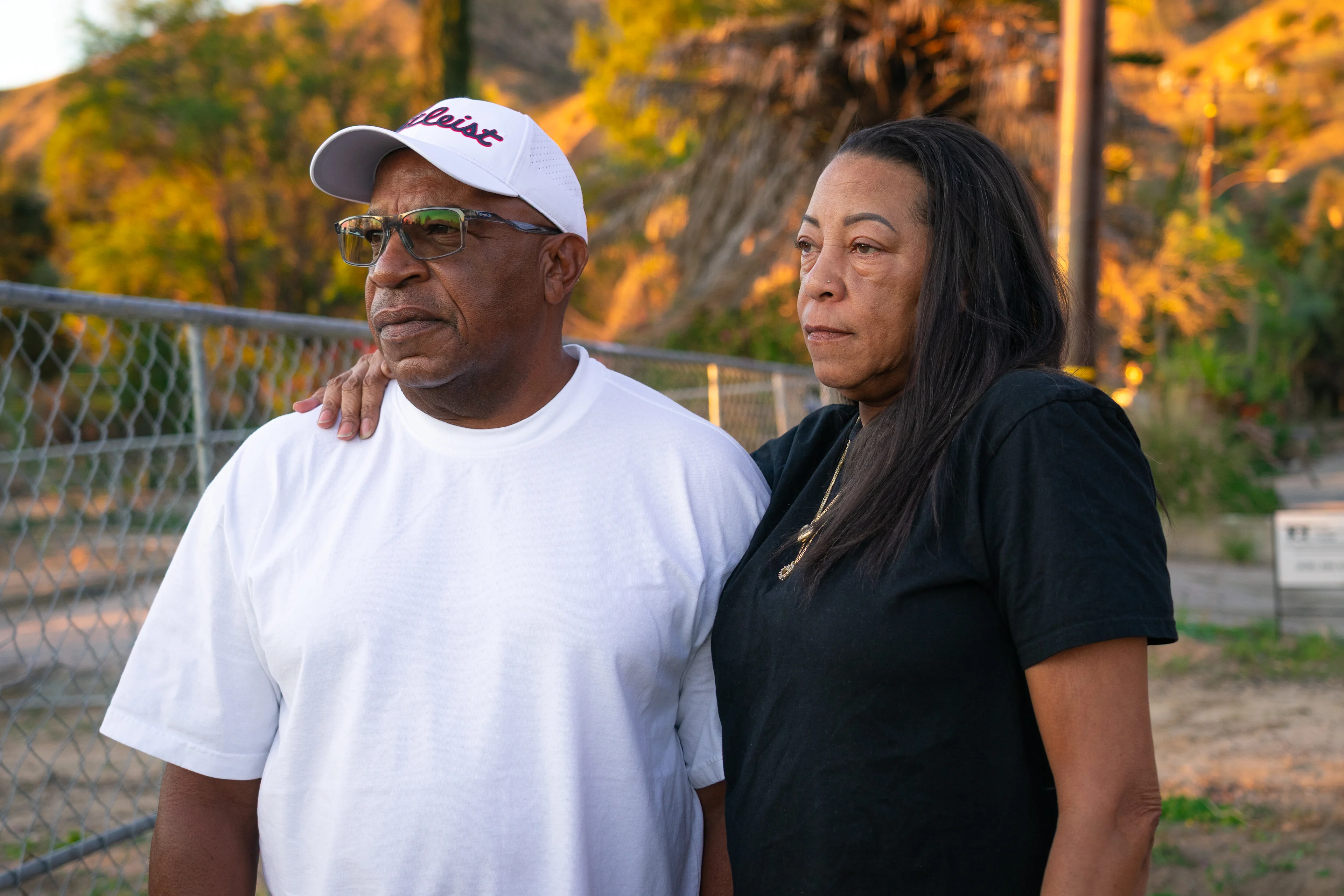 A close up profile photo of a woman with one arm around a mans shoulders.