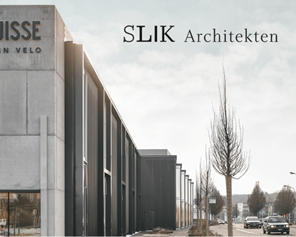 Slik Architekten - Thumbnail Modern commercial building exterior with SLIK Architekten logo, featuring dark metal facades and bare trees along the street.