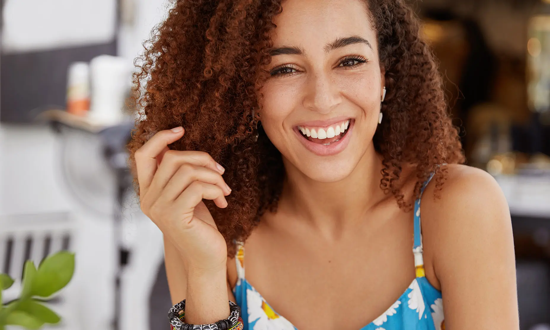 Curly hair talent smiling and touching hair 