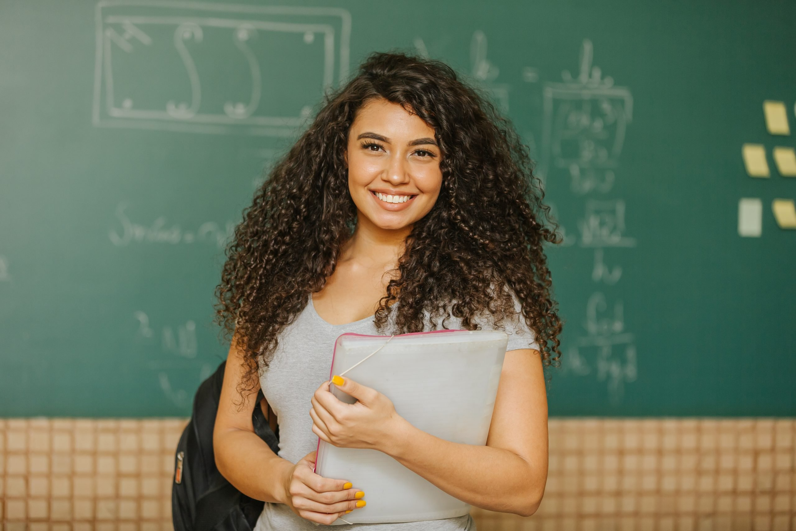 Curly hair talent holding books in school 