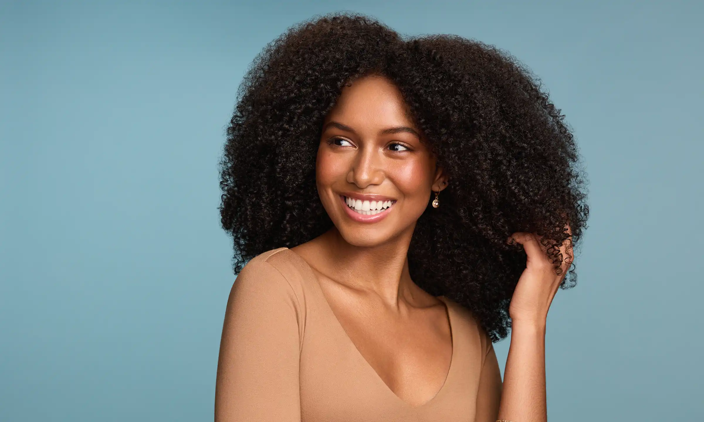 Woman smiling running her hand through her hair