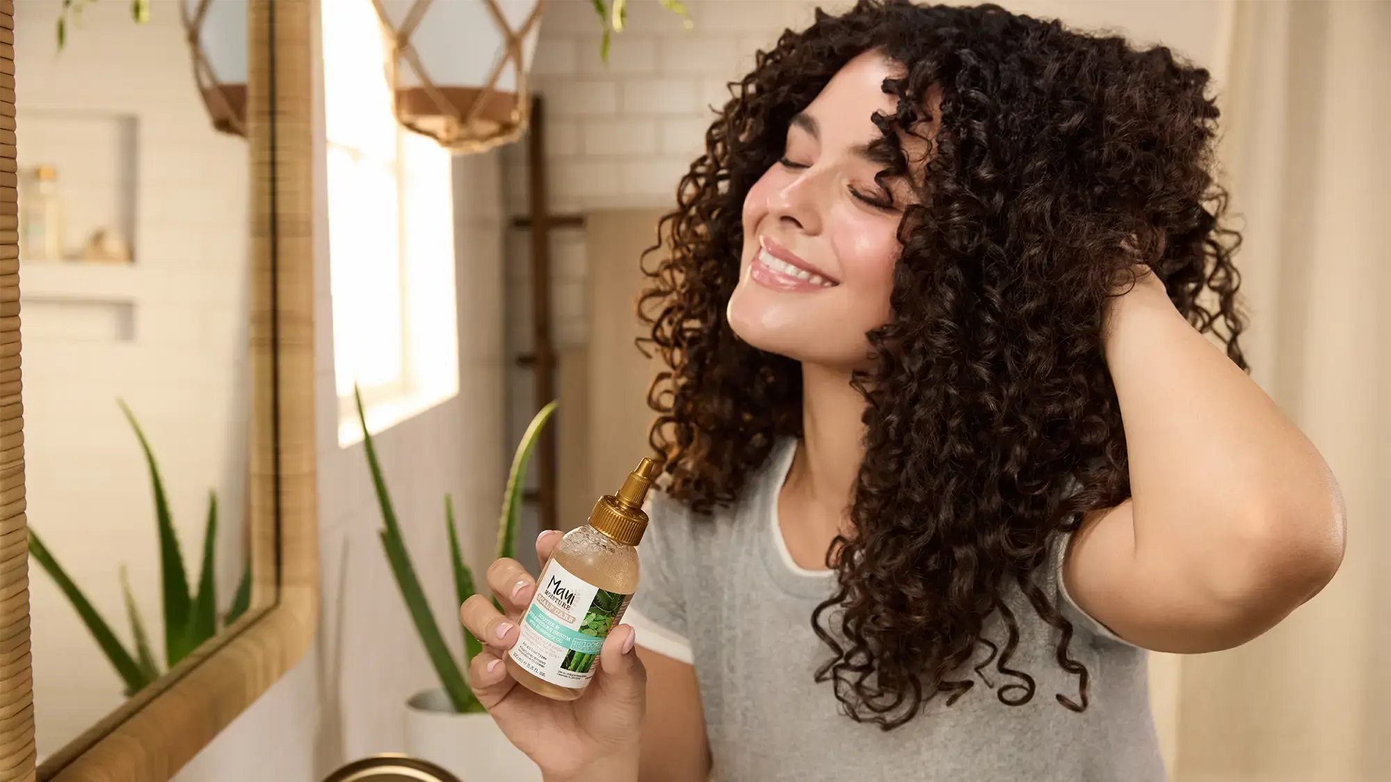 Smiling Woman with healthy curls using Maui Moisture Scalp Care Serum