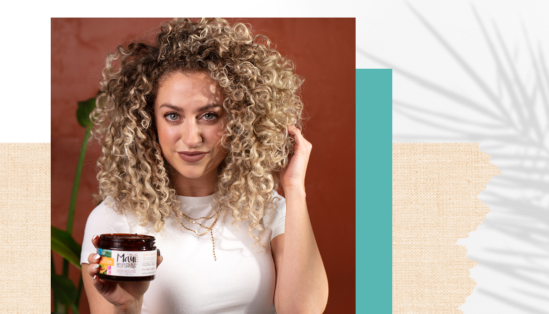 Maui Moisture talent with curly hair holding product on hand 