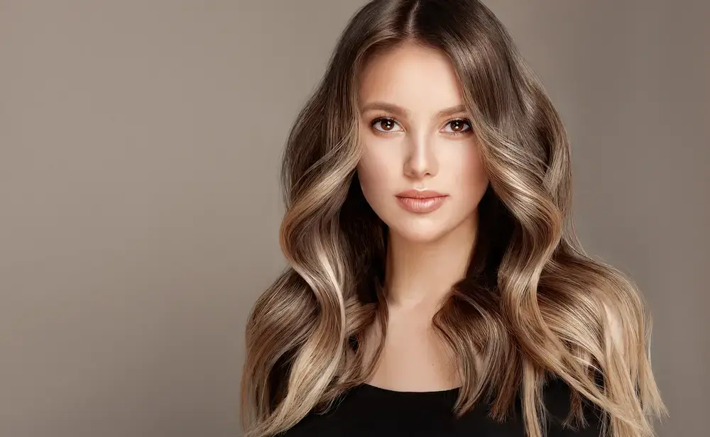 Woman with healthy blonde straight wavy hair after using Maui Moisture® products