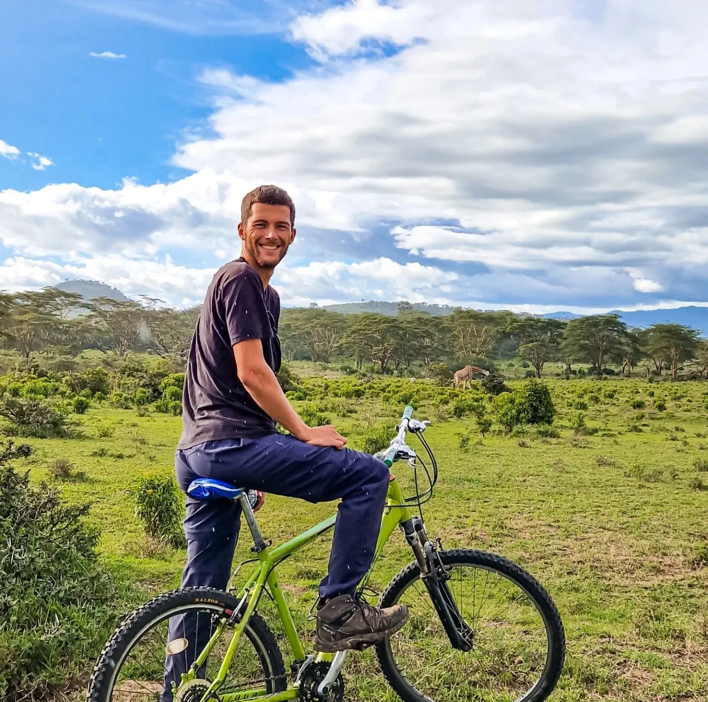 Pol on his bike, spotting a giraffe, in Lake Naivasha, Kenya