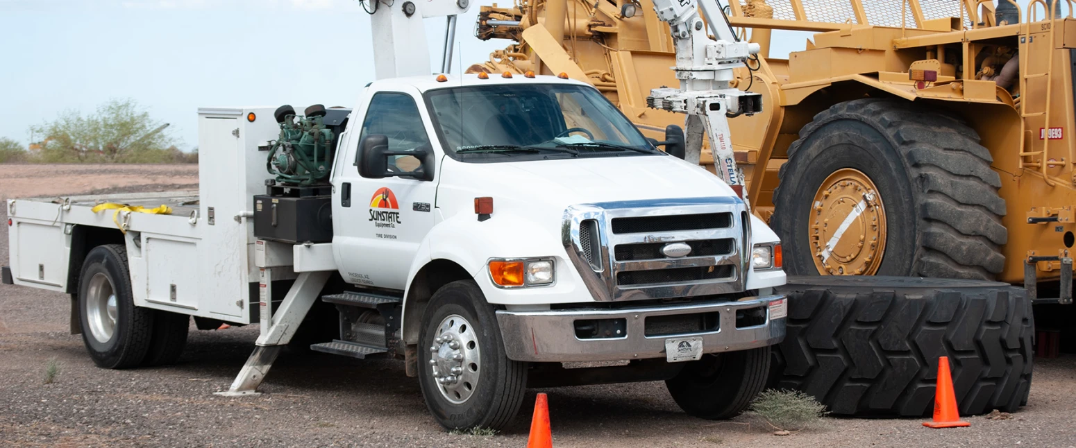 A Sunstate Equipment truck servicing tires on large earth moving equipment.