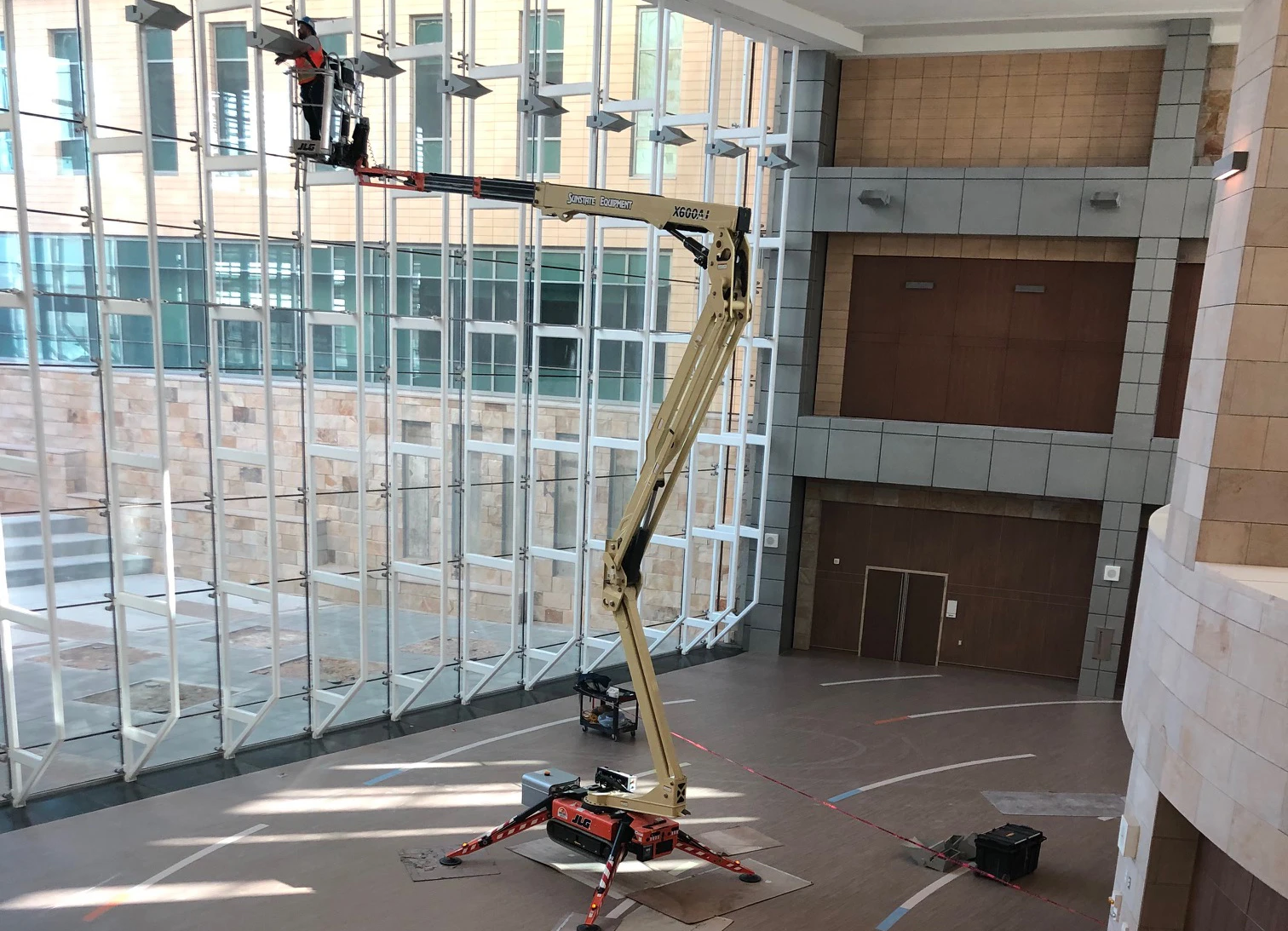 Glazing tall glass windows while using a Sunstate Equipment rental lift