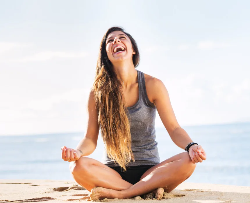 Woman sitting on the beach and smiling