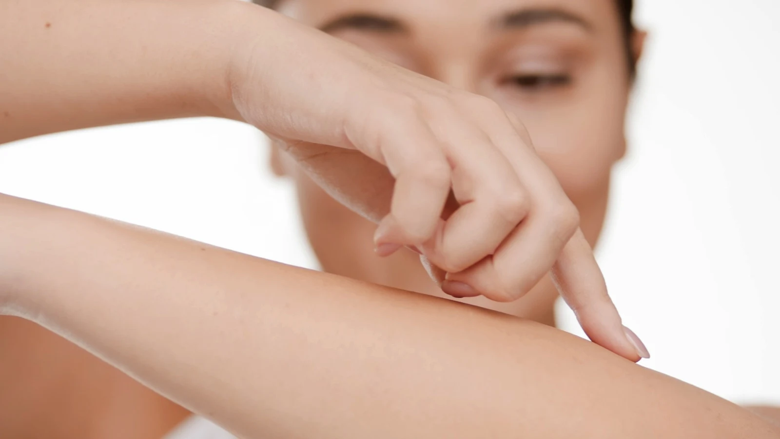 Mujer tocándose el brazo suavemente