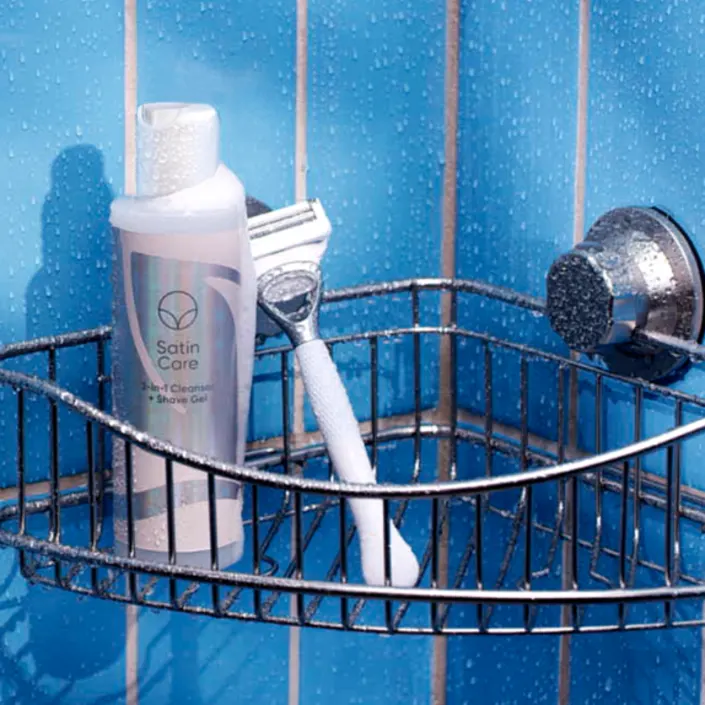 Satin Care 2-in-1 Cleanser and Shave Gel and Venus Bikini Skin Care razor placed on the floor in the bathroom
