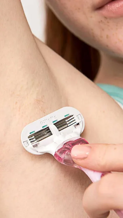 Woman shaving armpit with Disposable razor