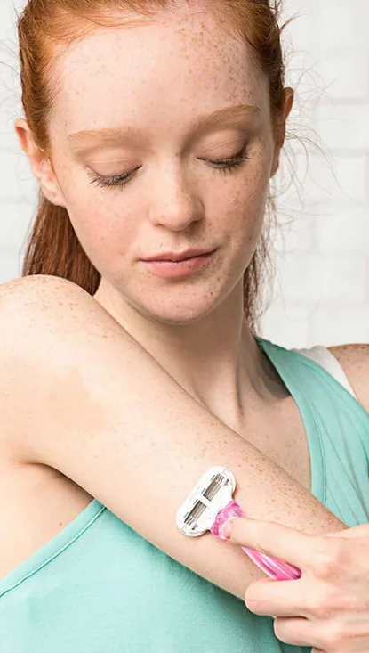 Woman shaving arm with Disposable razor