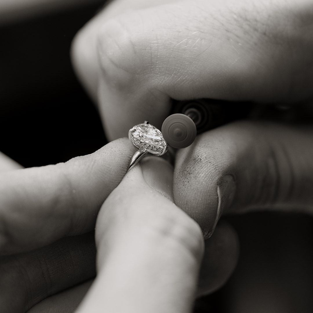 Image of a jeweller's hands, polishing a diamond