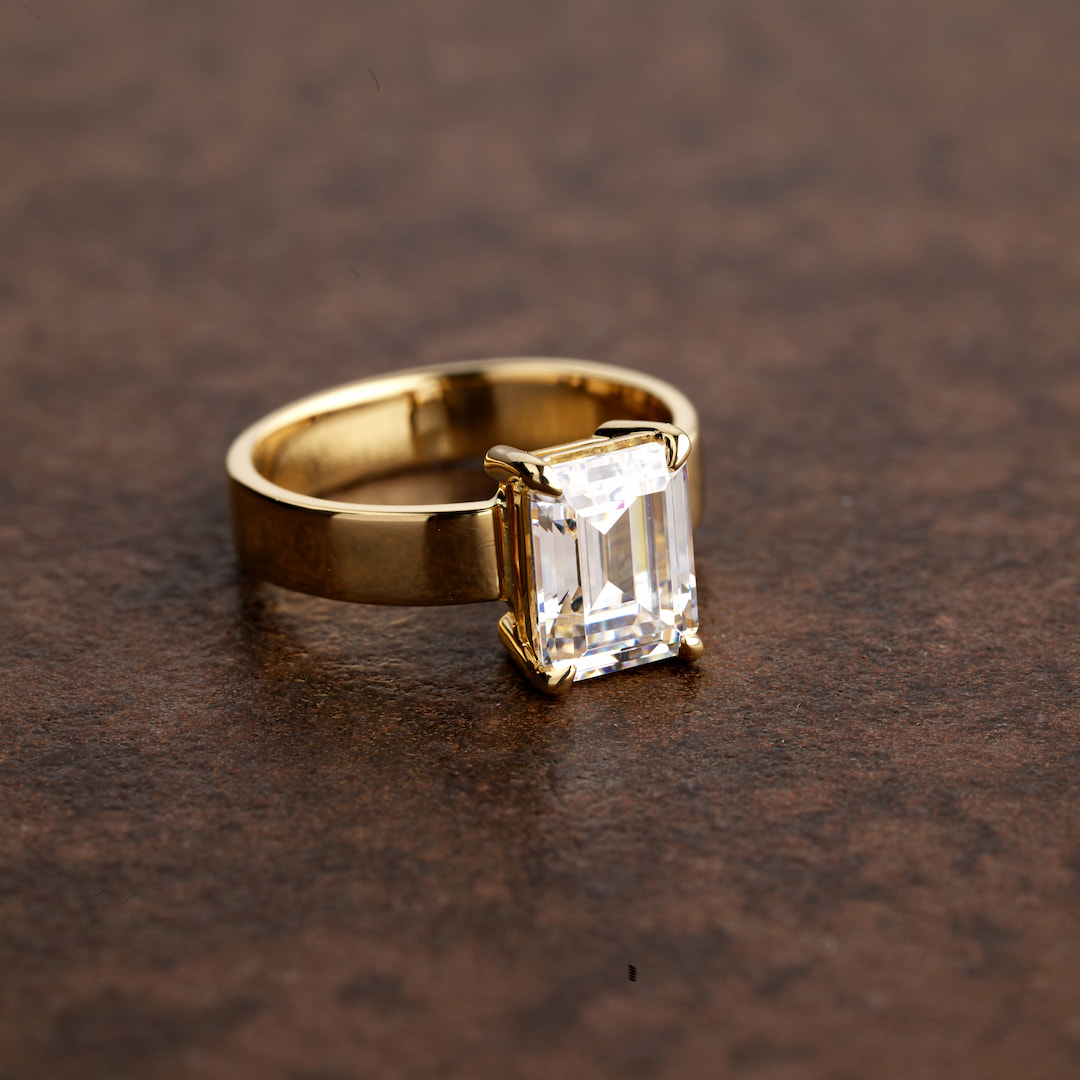 a thick-banded gold ring with an emerald-shaped diamond