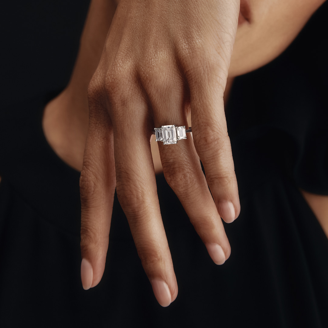 Woman's hand with emerald diamond in white gold ring 