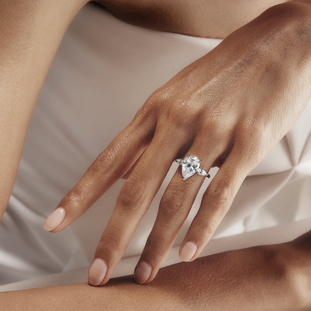 A woman's hand with a pear-shaped diamond ring