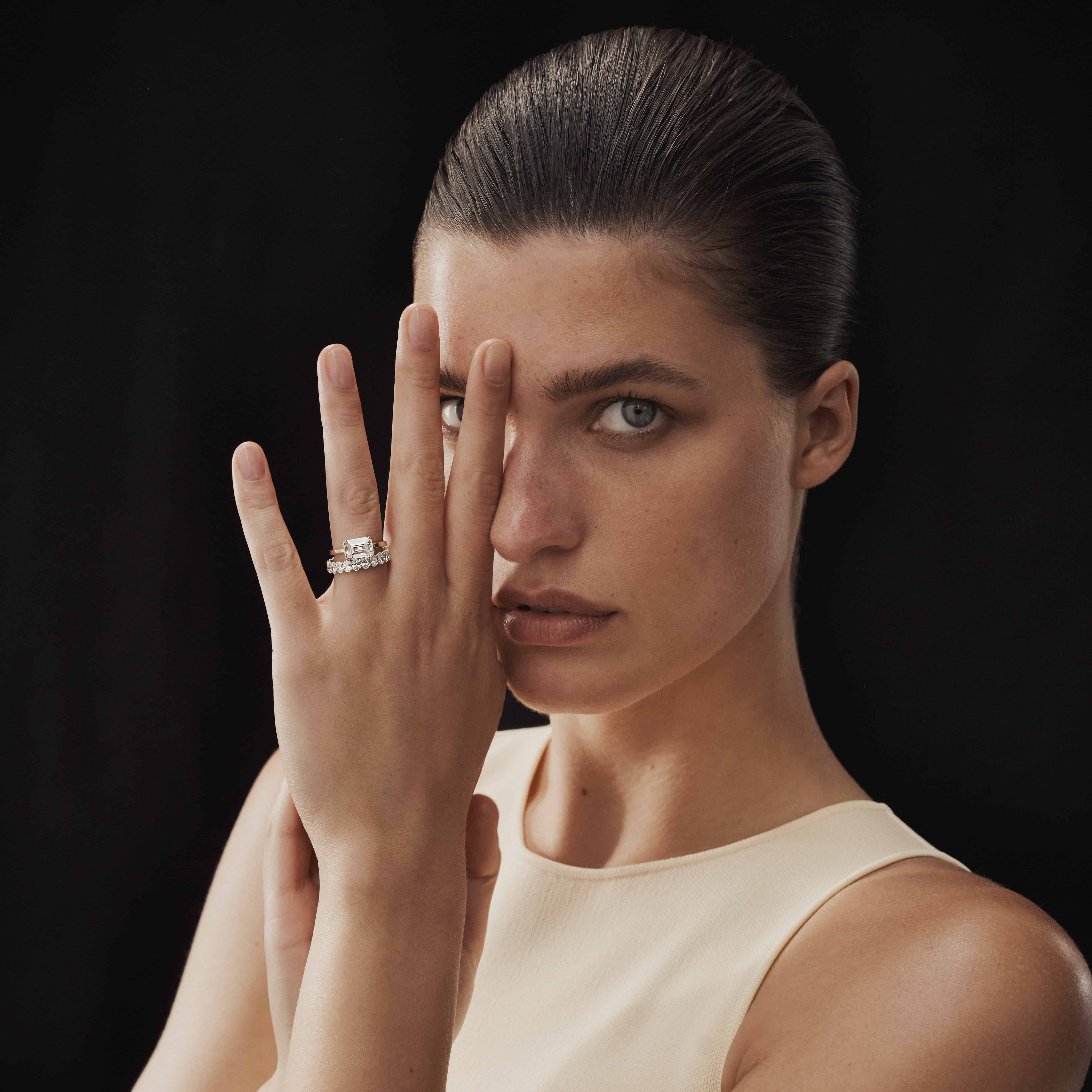 Image of young woman wearing a custom engagement ring designed by TenSevenSeven