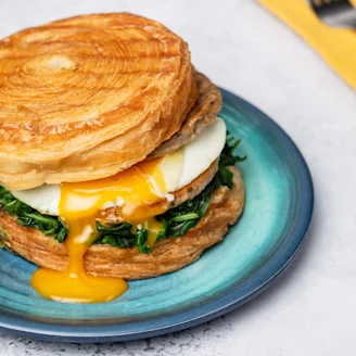 Egg sandwich with spinach on a blue plate