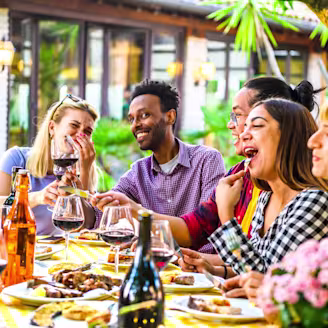 A group of people around a table enjoying food and drinks