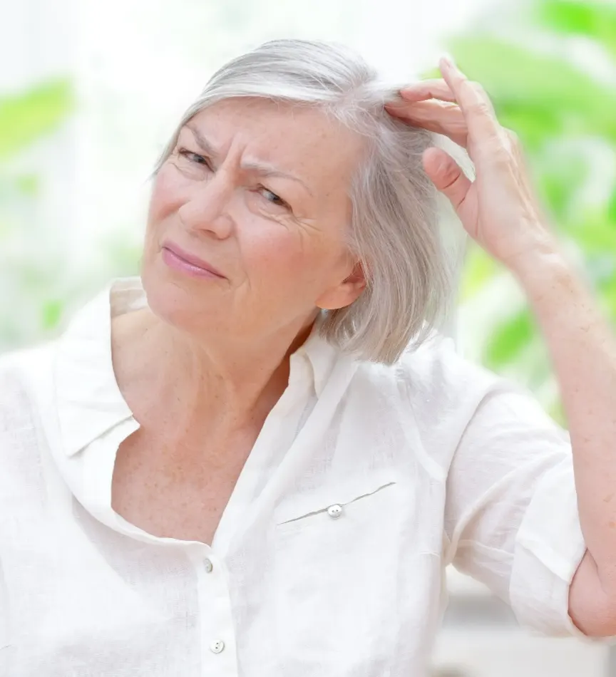 Anxious senior woman showing her scalp through thinning grey hair