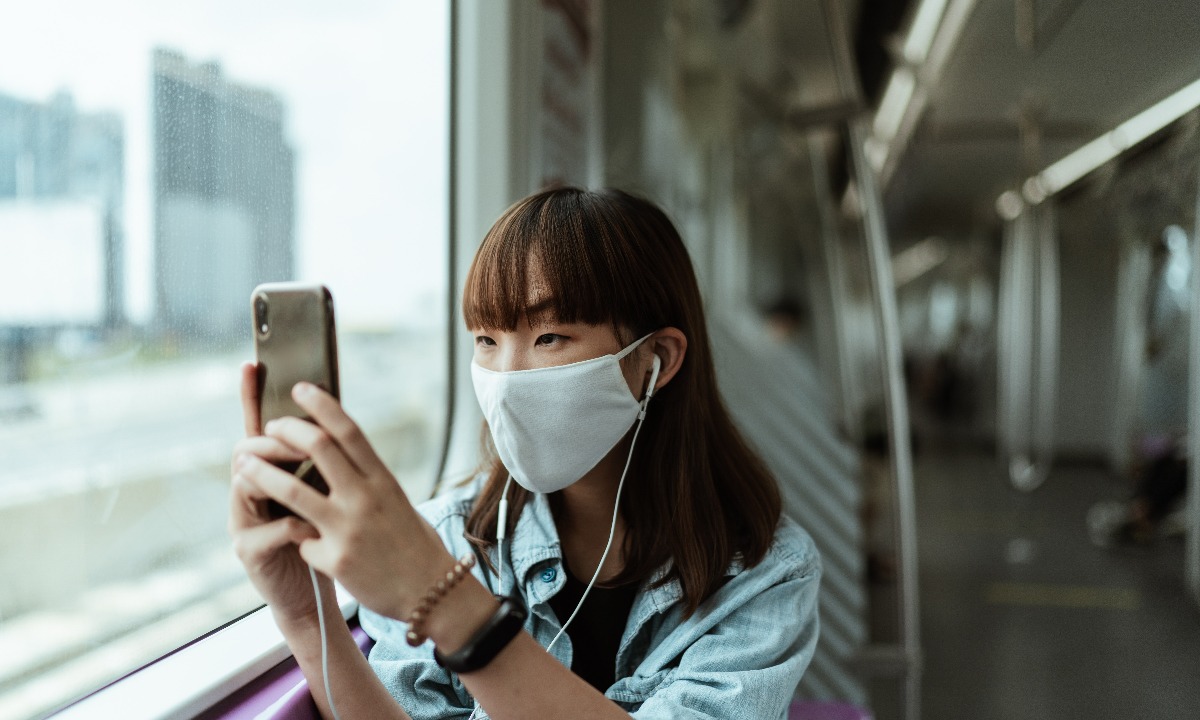 a woman wearing a mask and holding a phone