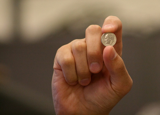 a hand holding a coin