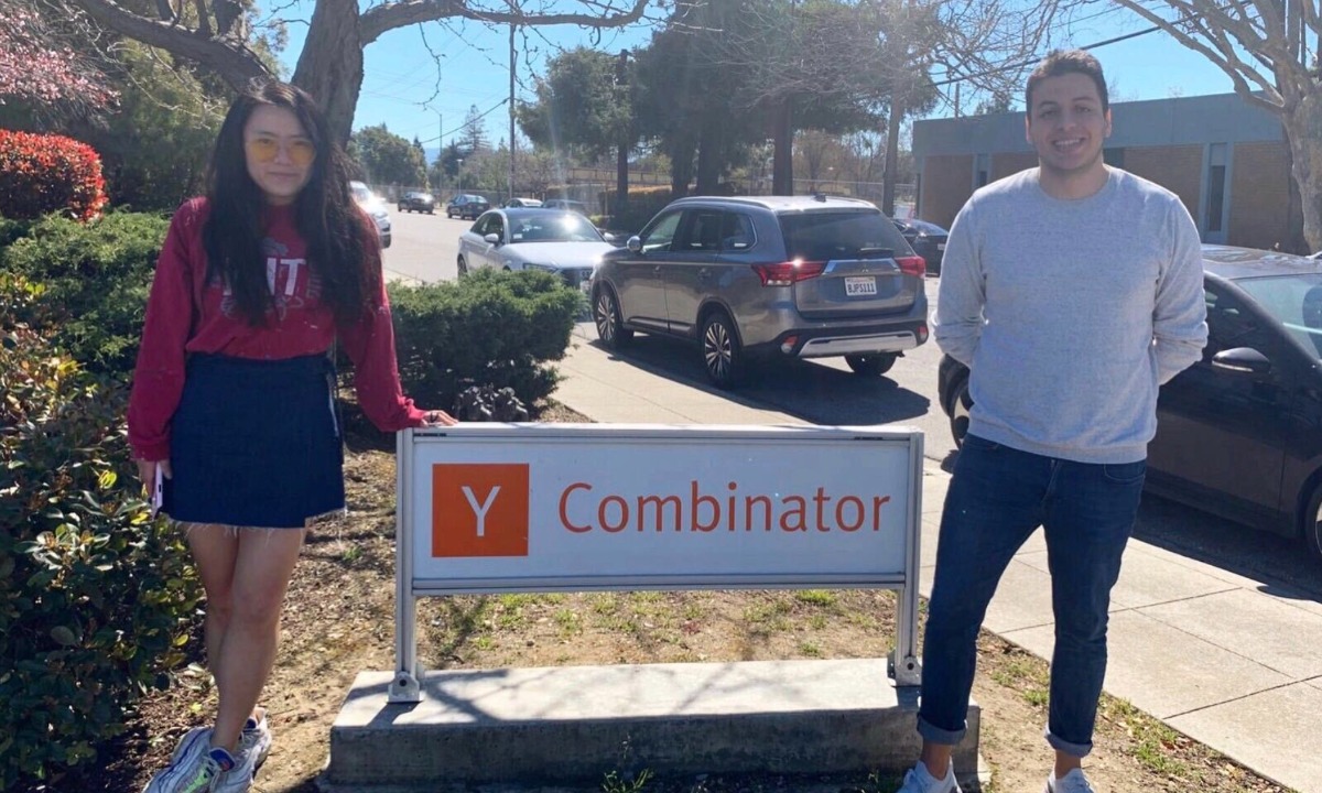 a man and woman standing next to a sign