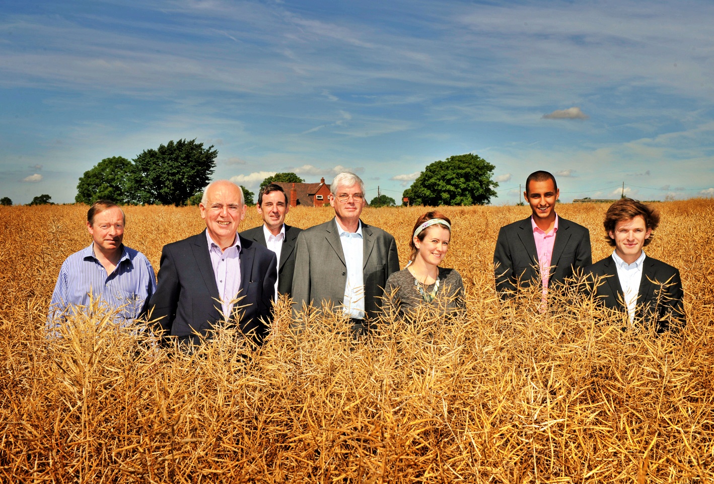 a group of people standing in a field of wheat