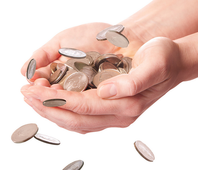 a hand holding a handful of coins