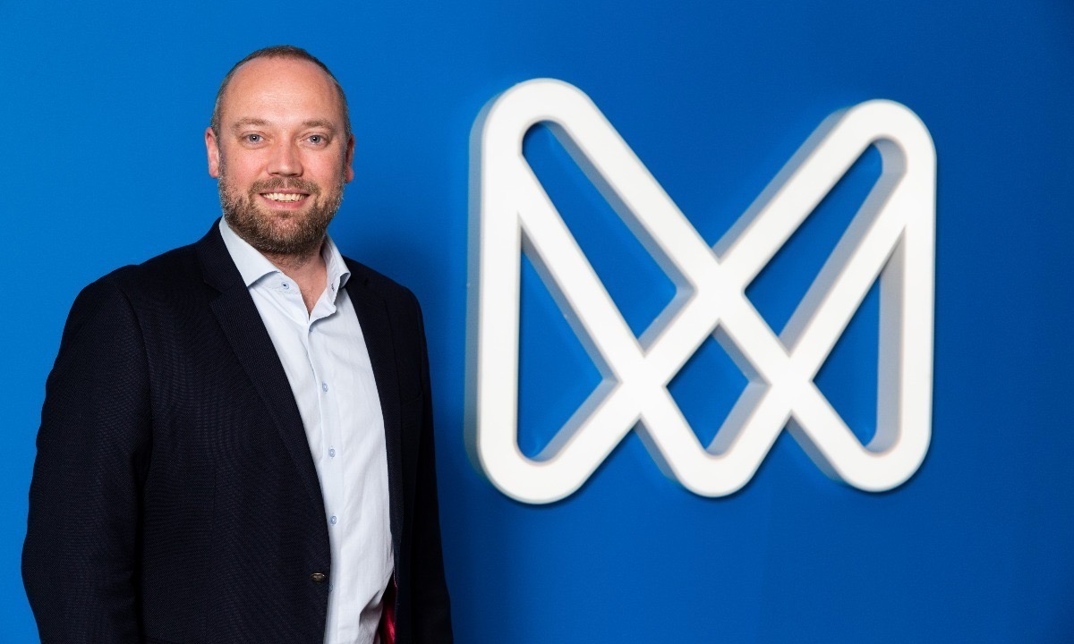 a man standing in front of a logo