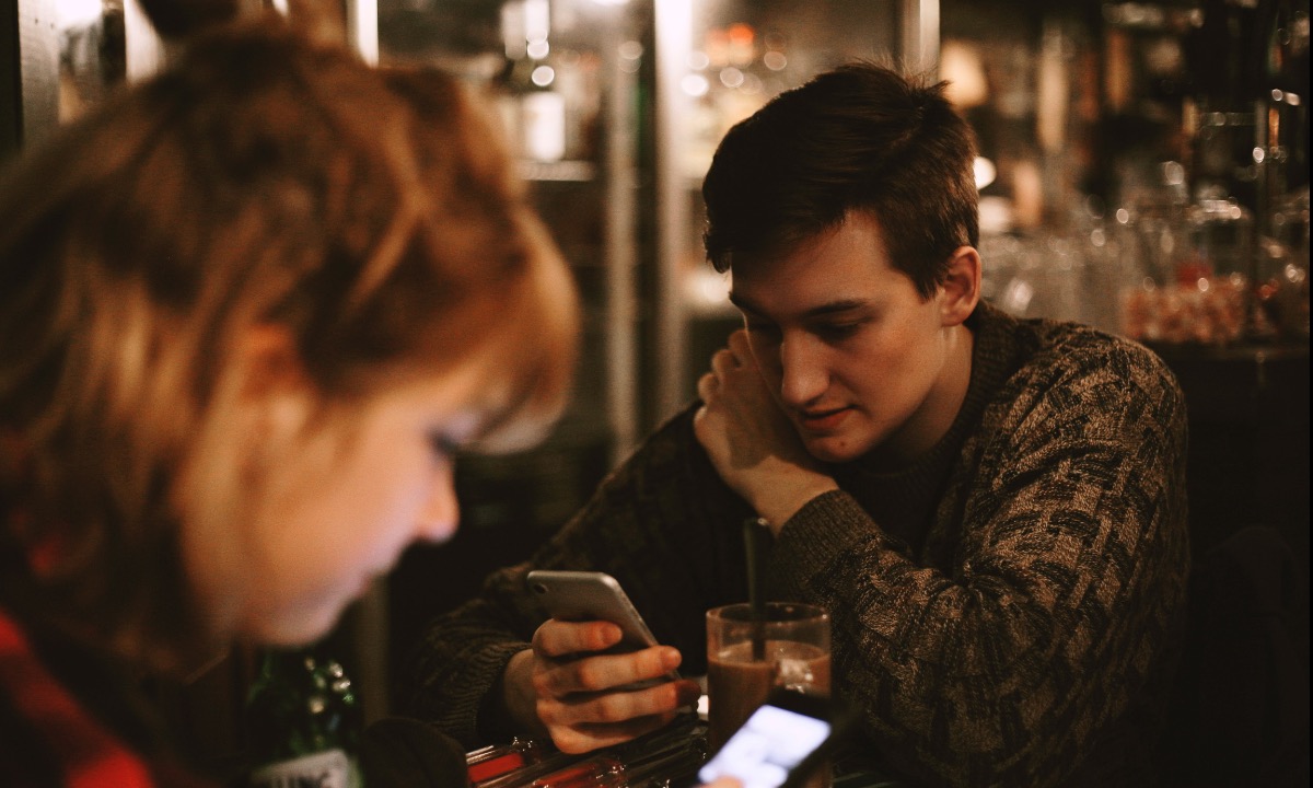 a man and woman looking at their phones