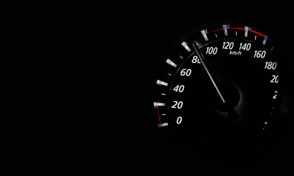 a black speedometer with red and white numbers