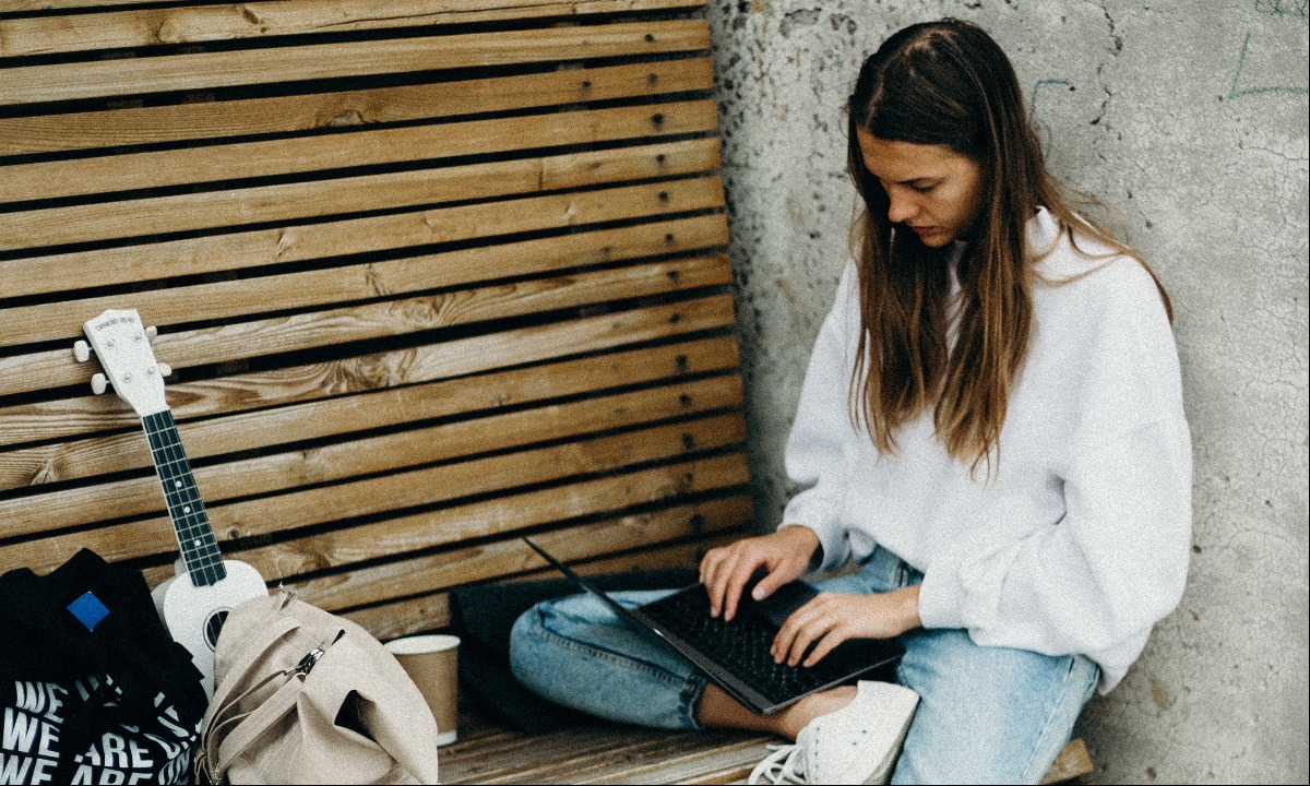 a woman sitting on the floor with a laptop