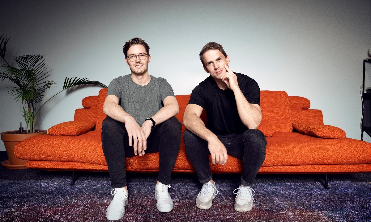 two men sitting on a couch