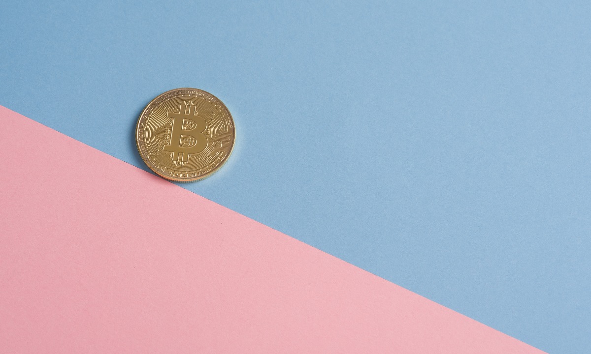a gold coin on a pink surface