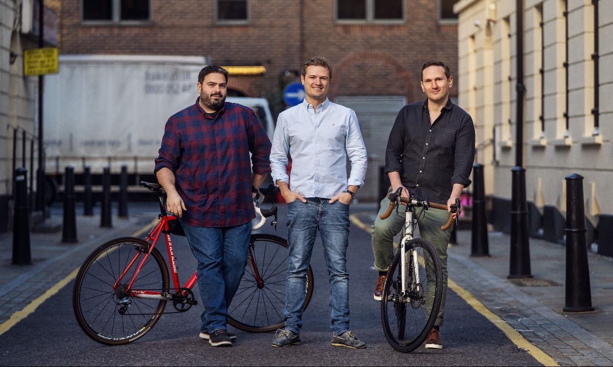 a group of men posing for a picture with a bicycle