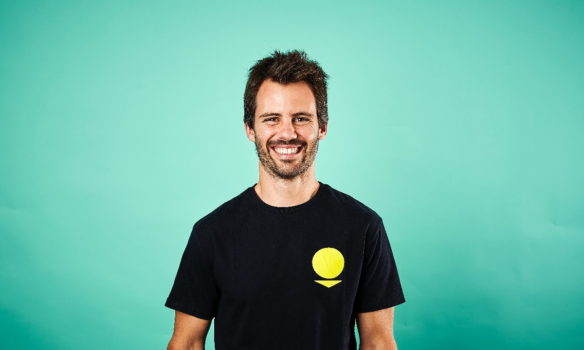 a man smiling with a yellow ball