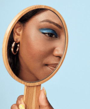 Woman looking into a handheld mirror