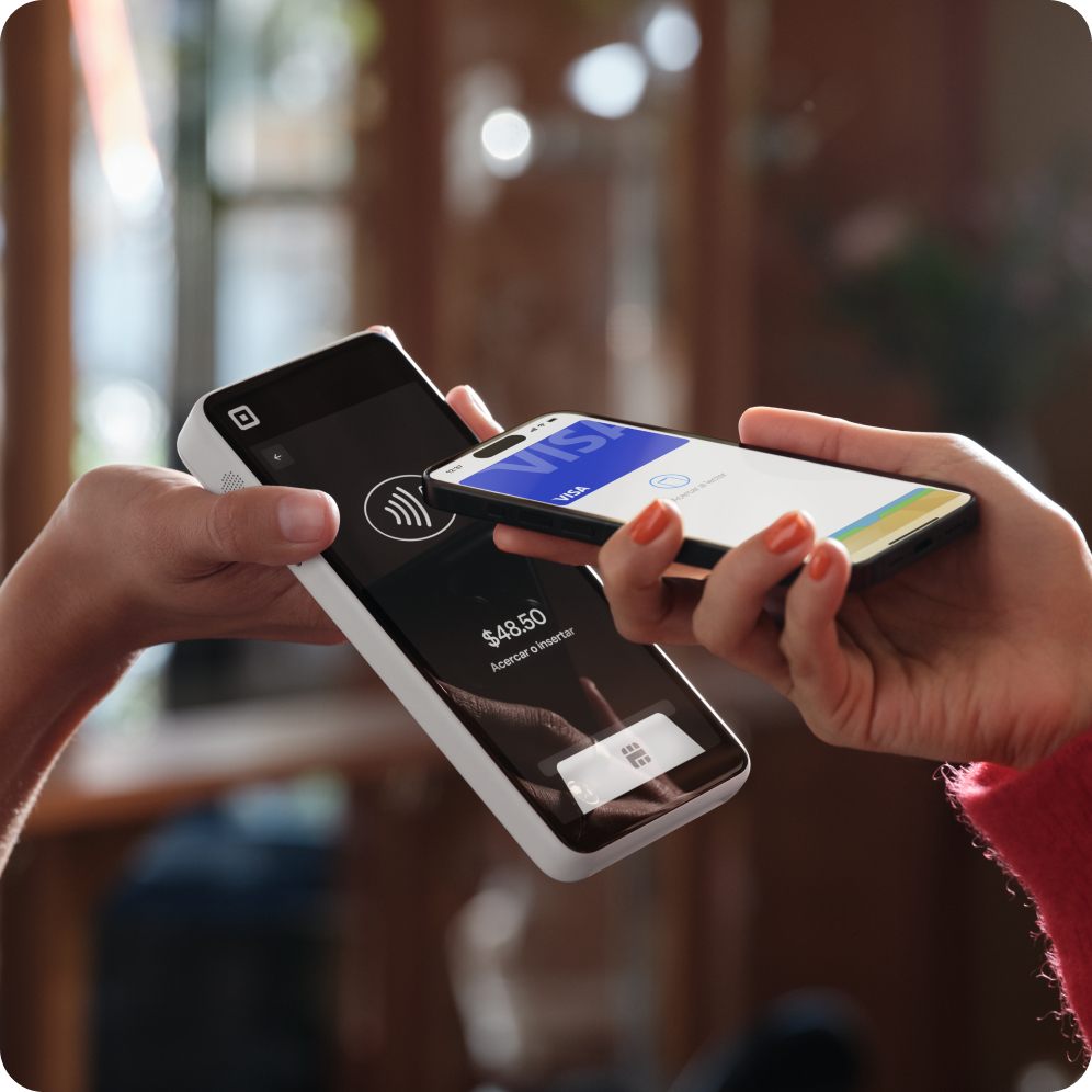 Customer tapping iPhone on Square Handheld to pay