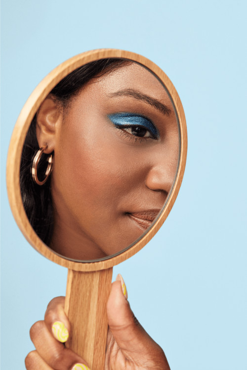 Woman looking into a handheld mirror