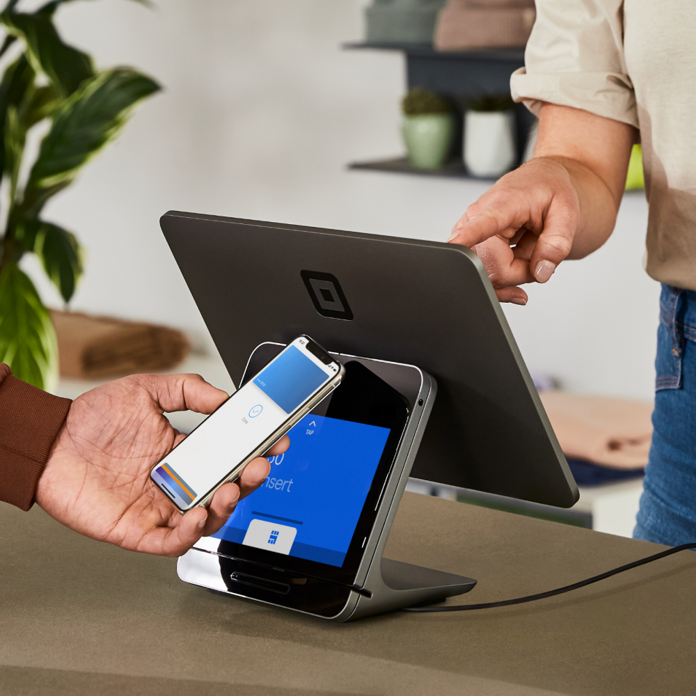 Customer tapping phone on Square Register at retail store