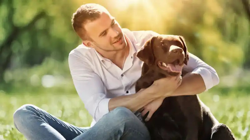 Photo of a guy sitting with a dog