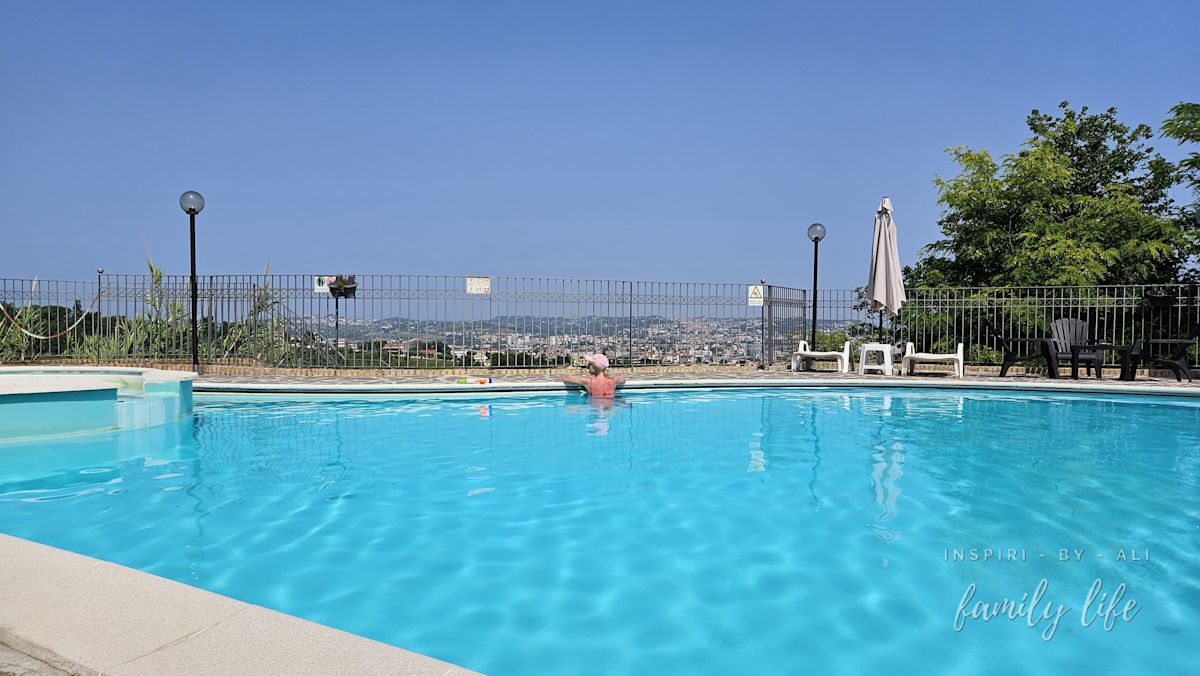 Basen z widokiem na miasto, wzgórza i góry